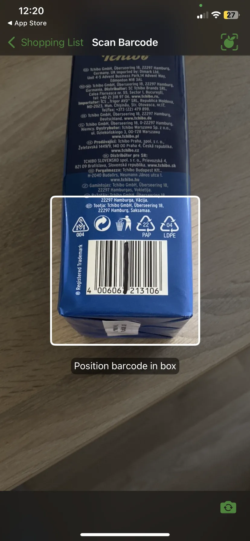OurGroceries' Scan Barcode screen framing the barcode on a Tchibo coffee pack, with the prompt "Position barcode in box"